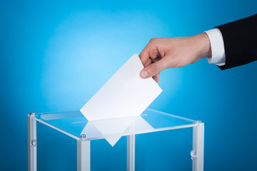 Businessman Putting Paper In Election Box