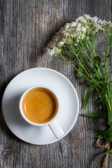 Espresso coffee and a small bouquet of flowers