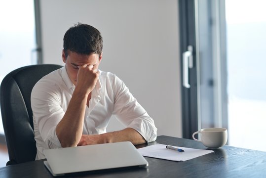 frustrated young business man working on laptop computer at home