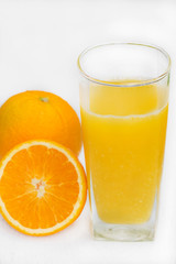 Glass of freshly pressed orange juice with sliced orange  on woo