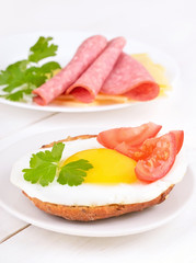 Sandwich with fried egg, tomato slices and parsley