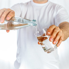 Water poured from bottle to glass