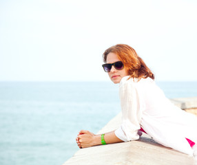 beautiful girl in sunglasses on background of the sea