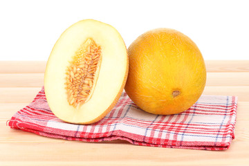Ripe melons on wooden table on white background