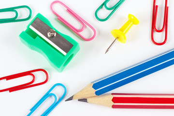 Pencil, paperclips, sharpener and pushpin on white desktop