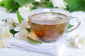 Cup of tea with jasmine on table close-up
