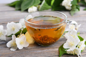 Cup of tea with jasmine on table close-up
