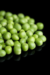 Fresh green peas isolated on black background