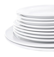 Set of white dishes on table on light background