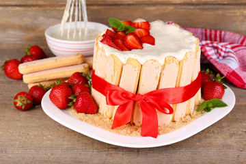 Tasty cake Charlotte with fresh strawberries on wooden table