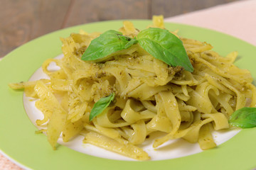 Delicious pasta with pesto on plate on table close-up
