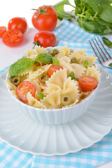Delicious pasta with tomatoes on plate on table close-up