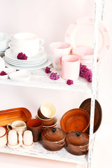 Different tableware on shelf, isolated on white