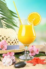 Refreshing orange cocktail on sand beach