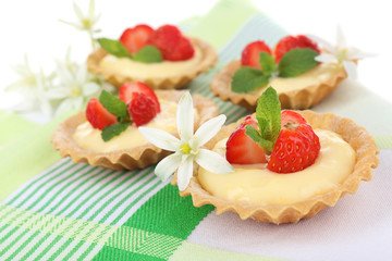Tasty tartlets with strawberries on table close-up