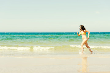 Fototapeta na wymiar happy woman running on the beach