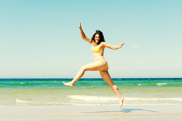 Happy girl jumping on the beach