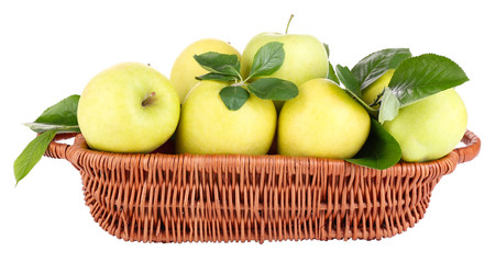 Ripe sweet apples with leaves in wicker basket, isolated