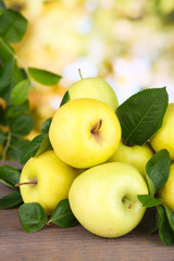 Ripe sweet apples with leaves on nature background