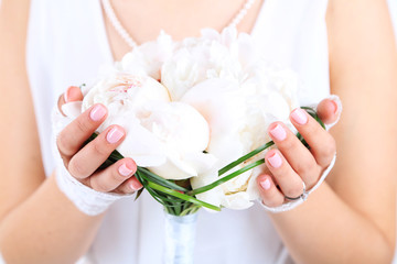 Bride holding wedding bouquet of white peonies, close-up