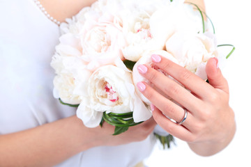 Bride holding wedding bouquet of white peonies, close-up