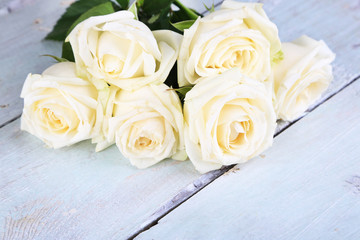 Beautiful white roses on wooden table