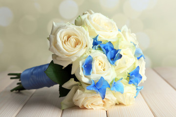 Beautiful wedding bouquet with roses on wooden table