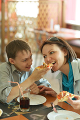 Mother and boy eating pizza