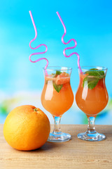 Grapefruit cocktail with cocktail straw on bright background