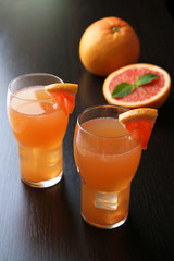 Grapefruit cocktail in glasses on wooden background