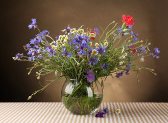 Beautiful wild flowers in vase on table
