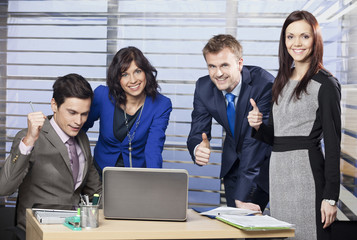 Successful business team giving thumbs up 