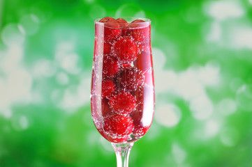 Elegant glass filled with mineral water with gas bubbles and jui