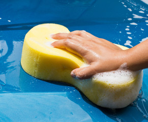 hand hold sponge over the car for washing