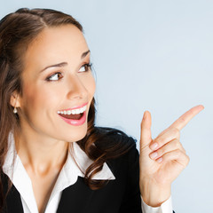 Businesswoman showing blank area for sign or copyspase, over blu