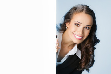 Businesswoman showing signboard, over blue