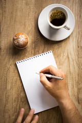 Man writing on paper, top view