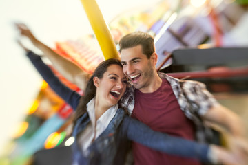 Laughing couple enjoy in riding ferris wheel