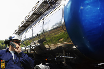 worker, driver and large fuel-truck inside refinery