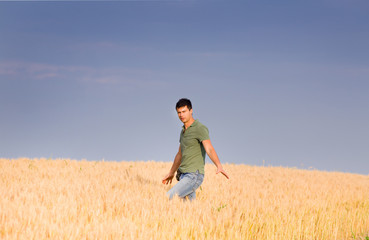 Naklejka na ściany i meble Attractive man in barley field