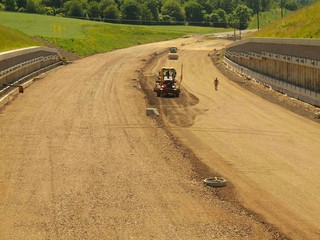 Building of new highway, scraper modify surface or gravel. 