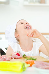 Obraz na płótnie Canvas Little girl in chef hat laughing in kitchen.