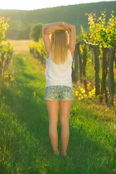 Beautiful young girl standing between grapes and do yoga