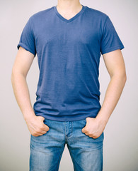 Man in blue t-shirt. Grey background.