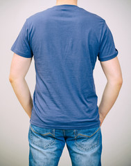 Man in blue t-shirt. Grey background.