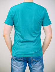 Man in turquoise t-shirt. Grey background.