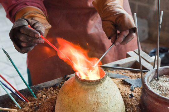 Glass artist in his workshop: making glass beads