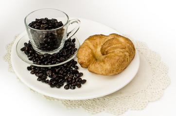 Cup of coffee beans with croissant