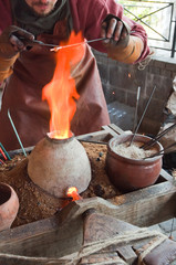 Glass artist in his workshop: making glass beads