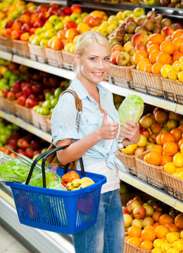 Girl at the shop choosing fruits and vegetables hands cabbage